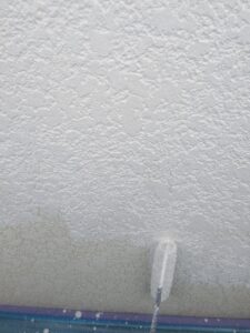 松本市A様邸 外壁下塗り作業の様子。塗料の密着性を高めるため、下地に丁寧に塗布している。